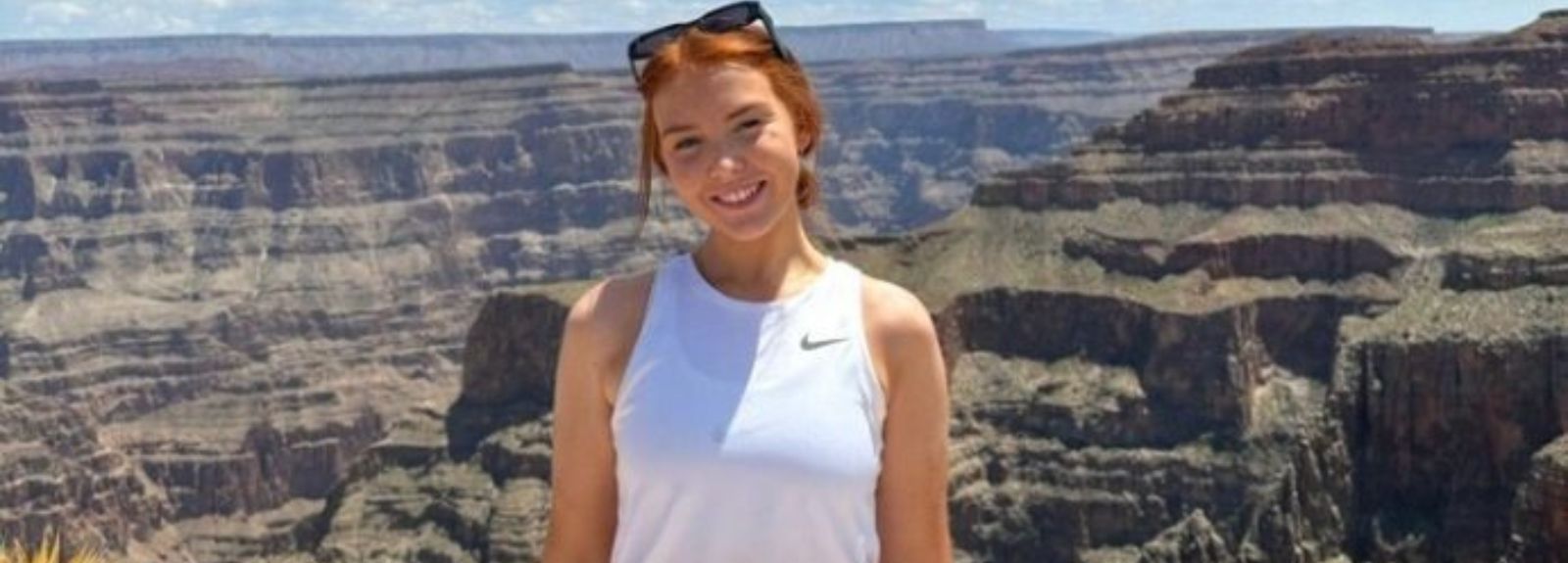 female student standing with a scenic background